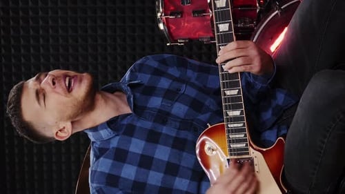 Guitarist with electric guitar at rehearsal studio. Vertical video
