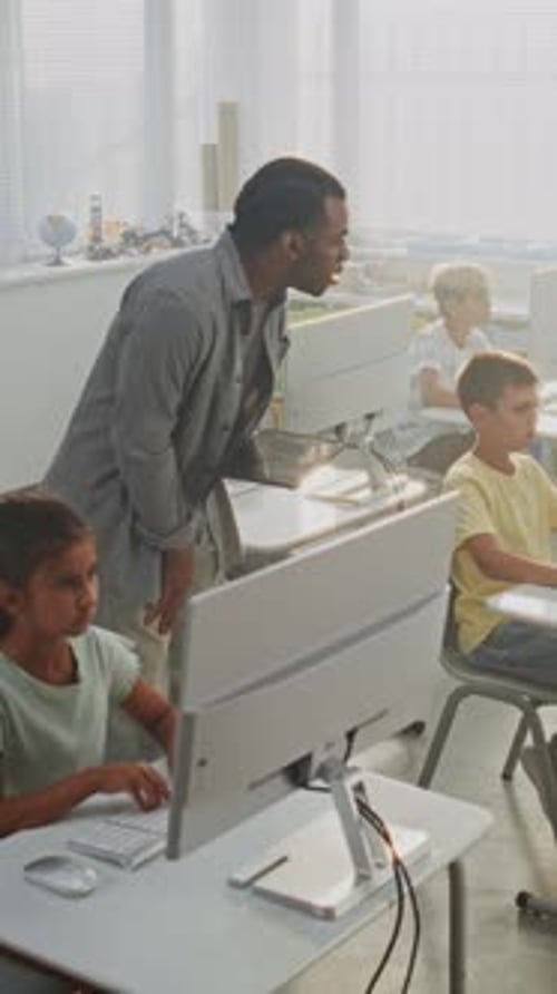 Teacher Helping Boys and Girls in Learning Coding During Programming Lesson