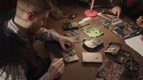 Technician Soldering Circuit Board at Work Desk