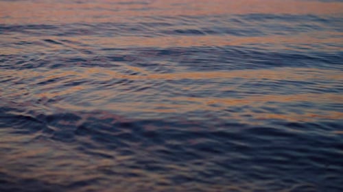 Closeup Sea Water Surface Reflecting Purple Sky at Evening Sunset Dawn. Close
