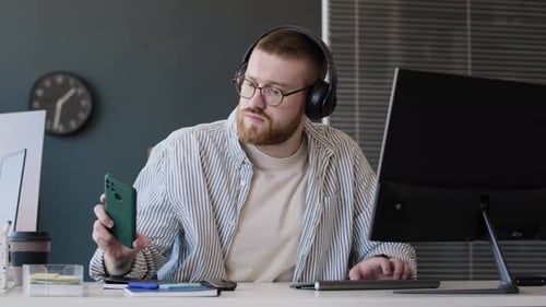 Man Checking Notification On Smartphone At Work