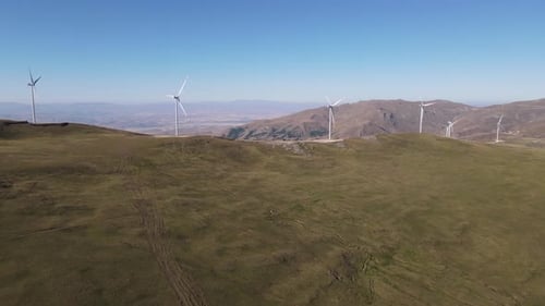 Drone view of wind turbines installed in mountain terrain, ecological power energy generation