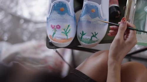 Woman Painting Nature Scene on White Canvas Shoes