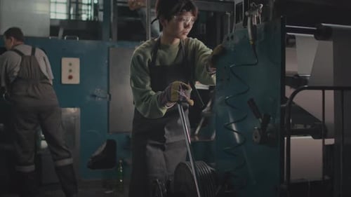Female Factory Worker Using Machine Equipment