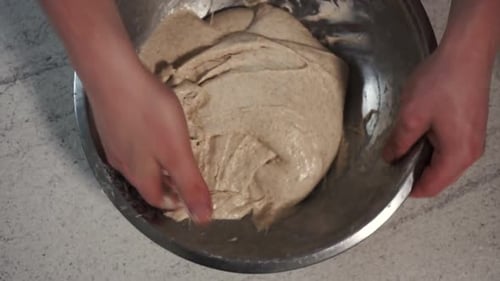 Man Kneading Dough in Silver Bowl