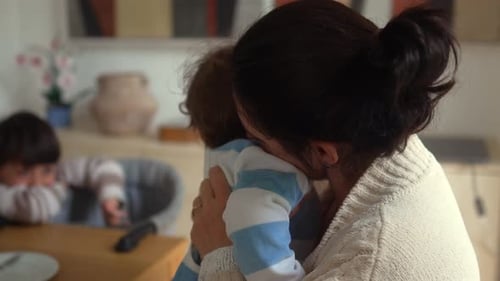 Loving mother embraces her baby at home