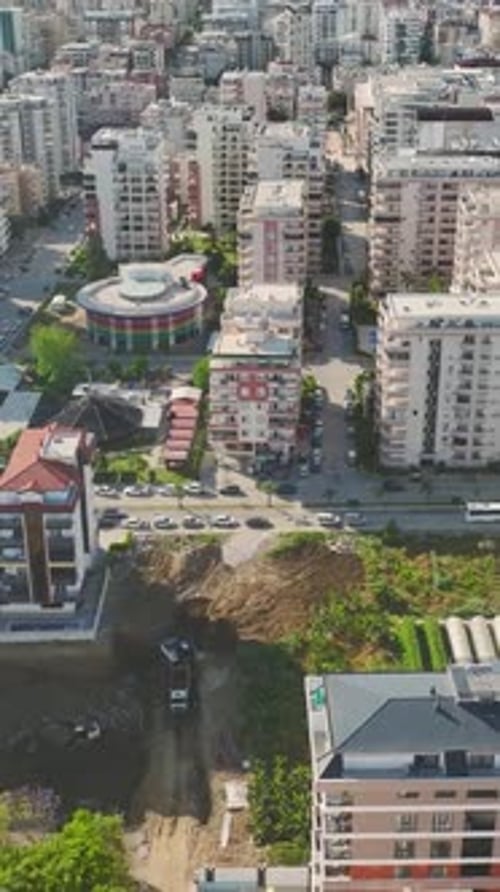 Vídeo vertical: trabajadores de la construcción utilizan maquinaria para construir infraestructuras