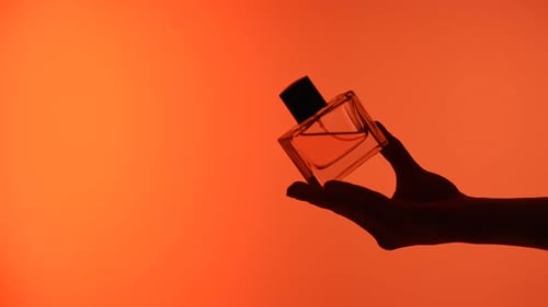 Silhouette of Hands Holding a Perfume Bottle