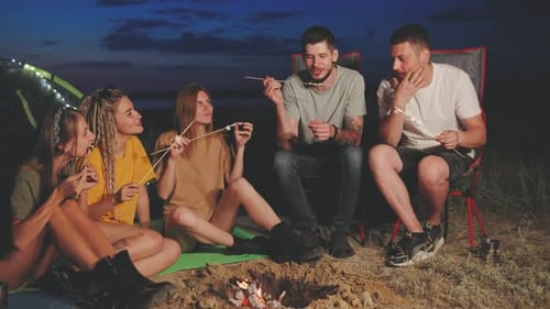 Close Friends Gather Together Around a Warm and Inviting Bonfire Sharing Joyful Laughter and