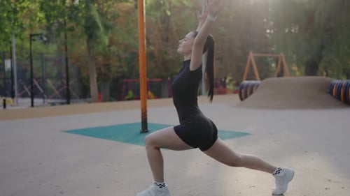 Young Woman Performing Outdoor Stretching Exercise at Park