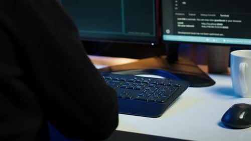 Close Up of Hacker Running Code in Apartment on PC Monitors