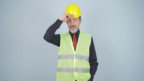 L'ingénieur portant un casque de sécurité et souriant.