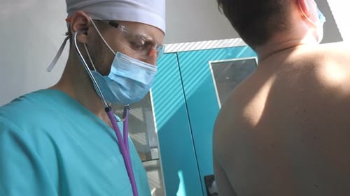 Doctor Examining Patient with Stethoscope in Hospital Room