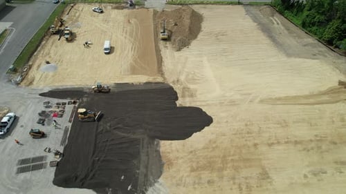 An aerial view of group of excavator and road rollers working on a construction site. A full view of
