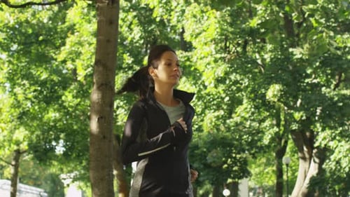 Attractive Woman and Man Running Together at Park in Bright Sunny Day.
