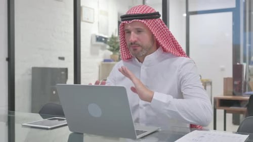 Man Using Laptop During Video Conference in Office