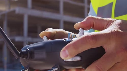 Professioneller Baumeister steht mit Schutzhelm und Weste vor dem Baustellenleiter
