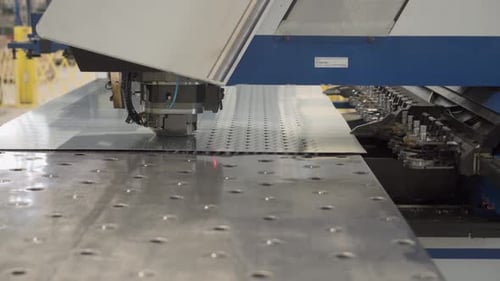 The operation of an automated machine at a factory for the production of lamps for street lighting.