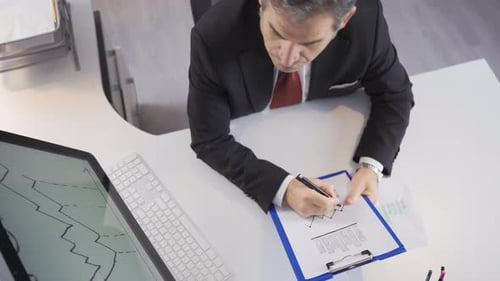 Businessman doing financial analysis on the chart in his hand.
