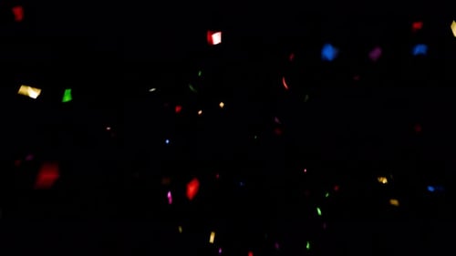 Colorful confetti pieces falling on black background. Festive celebration decoration for parties, ev