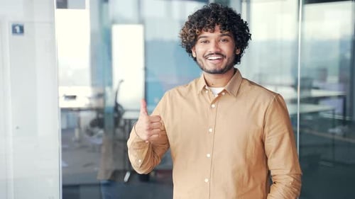 Smiling Young Adult Gives Thumbs Up in Office