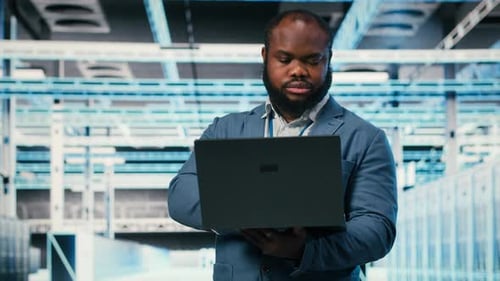 Happy Programmer in Server Hub Using Laptop to Do Maintenance Tasks