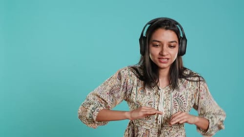 Happy Woman Playing Electronic Music and Waving Hand in Air