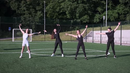Group of Women Exercising and Stretching on Soccer Field