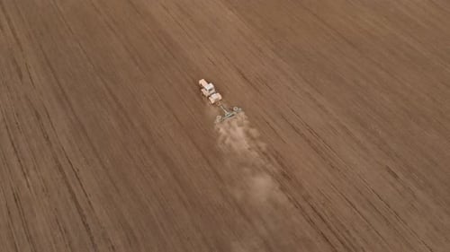 Aerial View of Tractor with Roller Rides on Field of Extruding Ground to Compact Soil and Levelling