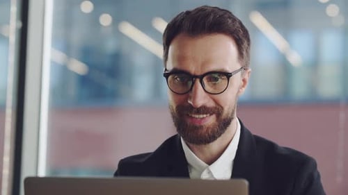 Man Working on Laptop in Modern Office
