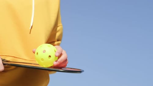 Pickleball Paddle and Yellow Ball Close Up Woman Playing Pickleball Game Hitting Pickleball Yellow