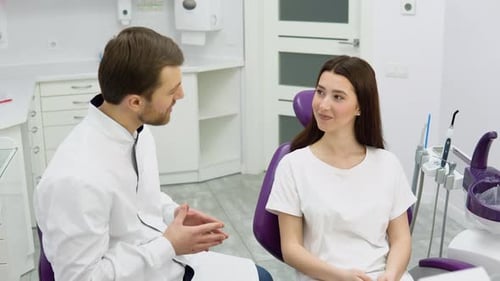 Experienced Doctor Dentist Talking to a Young Girl Patient