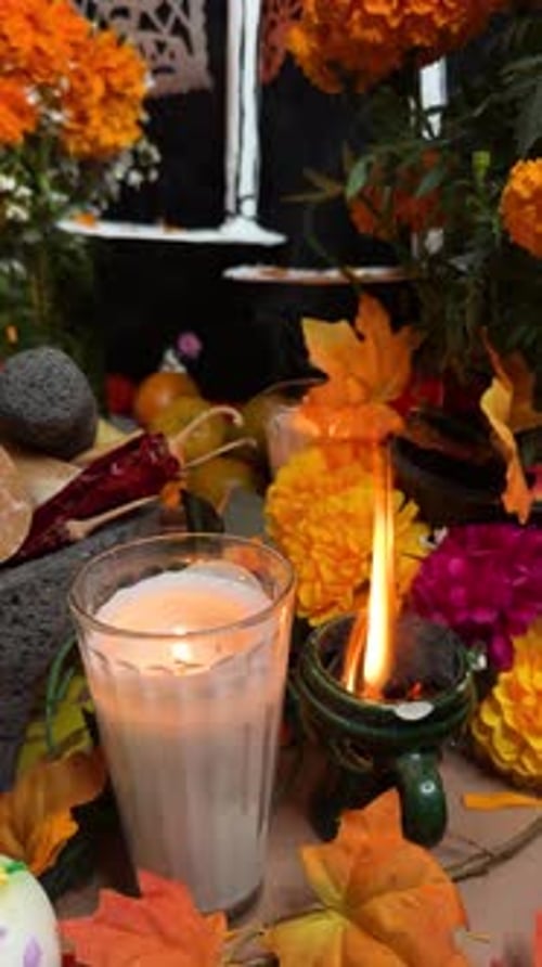 Velas encendidas en el altar del Día de Muertos con ofrendas, vídeo vertical