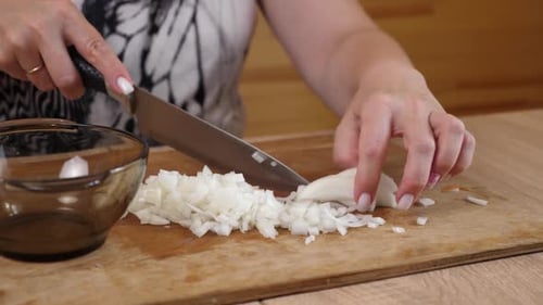 Woman Dicing Onion on Wooden Cutting Board
