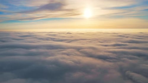 Aerial timelapse view from a drone flying above the moving lush clouds reflecting the sunlight