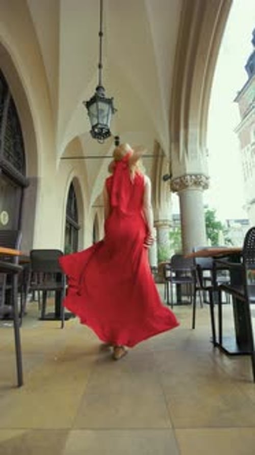 A Girl in Red Walks Among the Tables of the Restaurant