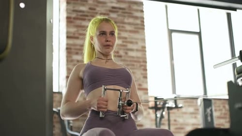 Gorgeous Female Professional Bodybuilder Doing Workout Exercises in Gym