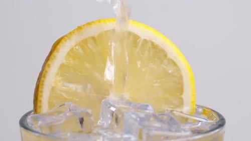 Pouring Water on Lemon Slice and Ice