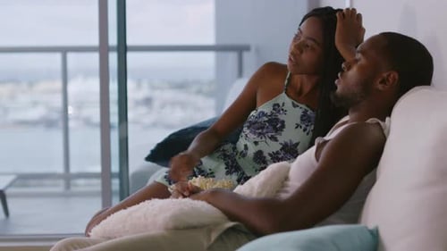 Couple Relaxing on Sofa Watching Television Together