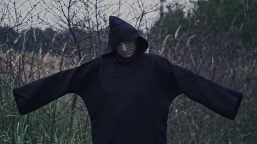 Horror figure in dark costume with hood.
