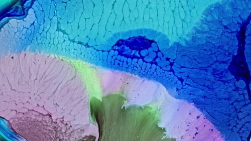 Vibrant blue and green ink spreading in water, creating an abstract pattern
