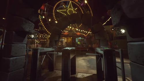 Empty Amusement Park at Night with Illuminated Rides and Quiet Atmosphere