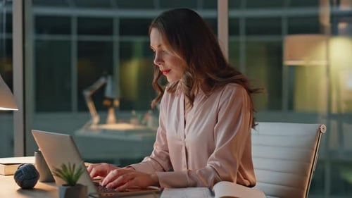 Ordenador portátil centrado en la escritura profesional nocturna, oficina, primer plano, mujer de negocios