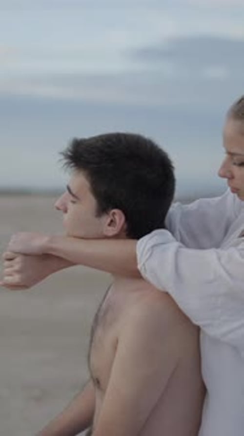 Woman Massages Man on Beach at Daytime