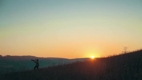 Child Running with Airplane on Hill at Sunrise