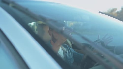 Frustrated Man in Car Grips Head in Despair