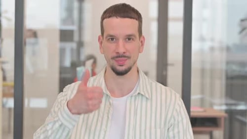 Smiling Young Man Gives Thumbs Up to Camera