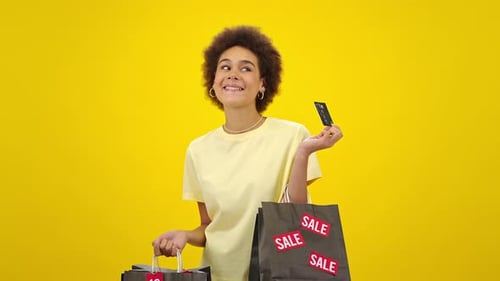 Actress Holds Shopping Bags and Shows Credit Card Smiling