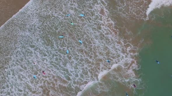 Top down rotating aerial of waves crashing on longboard surfers at ...