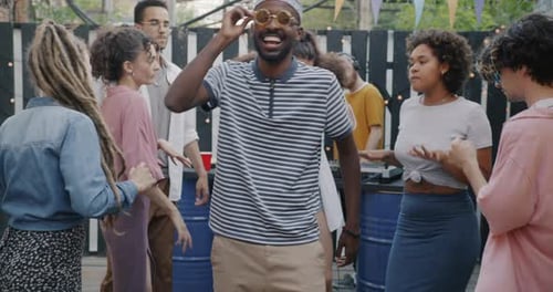 Slow Motion Portrait of Carefree African American Man Dancing at Outdoor Cafe Enjoying Party with